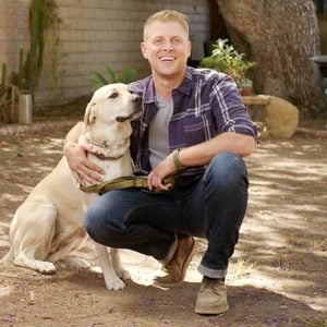 Luke bar sitting outside with a yellow lab dog